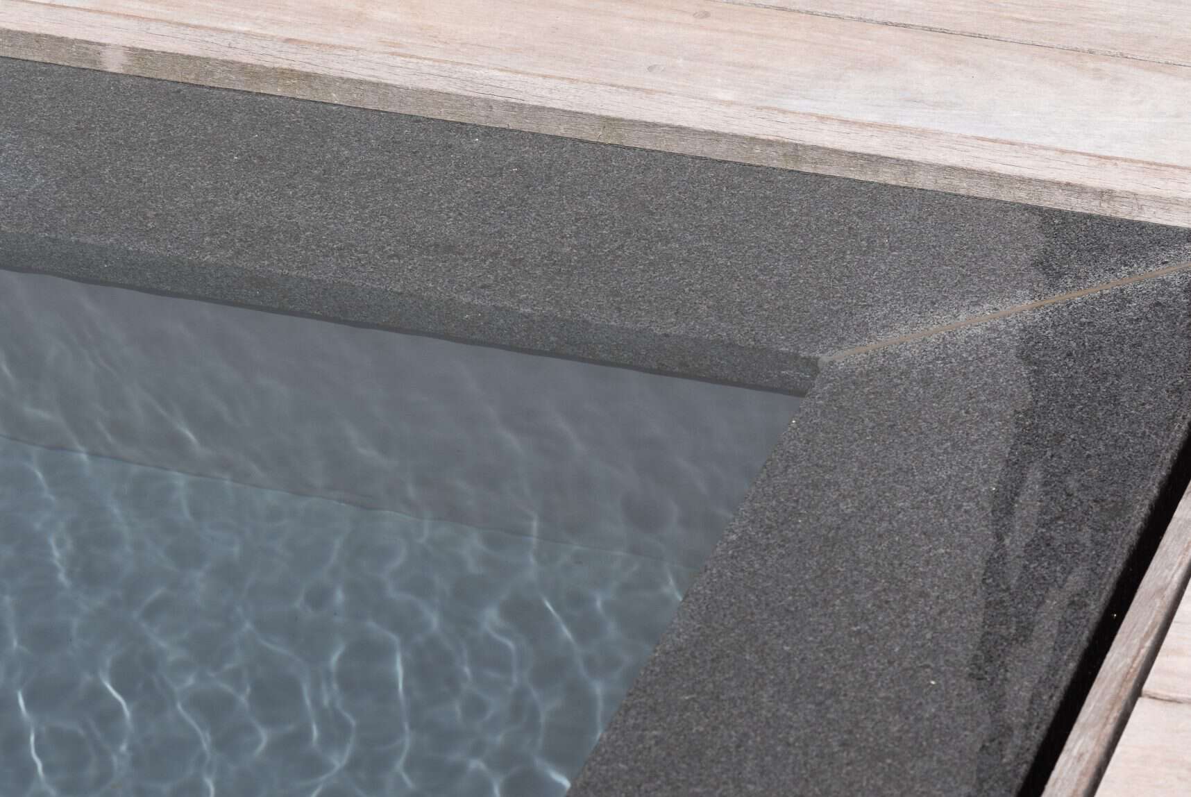Modern overloopzwembad met sfeervol houten loungeterras, luxe eettafel en een design booglamp.